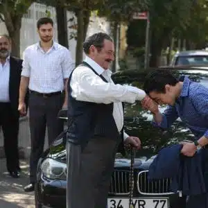 Hasan kissing Yakup's hand